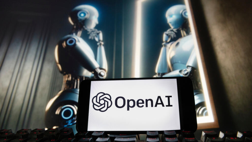 A smartphone displaying the OpenAI logo sits in front of three illuminated humanoid robot figures with glowing blue eyes against a dark background.